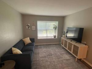 a living room with a blue couch and a flat screen tv at The Ingrid Apt #8 - Fresh and Simple 2bd with WiFi in Hamilton