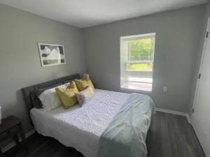 a bedroom with a bed with yellow pillows and a window at The Ingrid Apt #8 - Fresh and Simple 2bd with WiFi in Hamilton