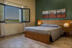 1 dormitorio con cama y ventana grande en Hotel Poggio Bertino, en Montemerano
