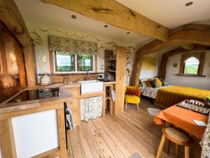 a room in a tree house with a kitchen and a bedroom at The Queen Bee Cabin in Hereford