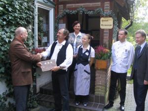 a group of people shaking hands outside a house at Landgasthof Rieger in Dangenstorf