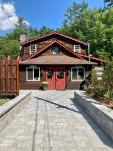 a log cabin with a red door and a driveway at Magnolia Streamside Resort in Canadensis