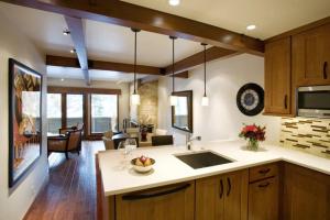 a kitchen with a sink and a living room at Luxury 1 Bedroom Downtown Aspen Vacation Rental With Access To A Heated Pool, Hot Tubs, Game Room And Spa in Aspen