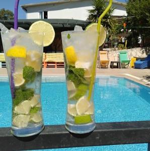 two glass vases filled with fruit and vegetables next to a swimming pool at TUTHALİYA HOTEL in Gelemiş