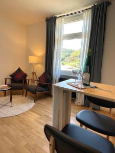 a living room with a table and chairs and a window at RiversideSuite.Mosel in Neumagen-Dhron