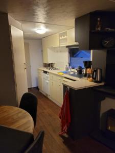 una cucina con armadietti bianchi e pavimenti in legno di Eexter bosparel caravan 222 a Eext