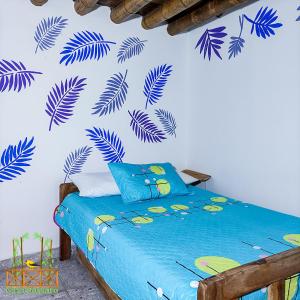 a bedroom with a blue bed with blue leaves on the wall at Casa Passaro 3 in Córdoba