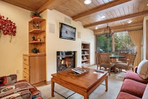 a living room with a table and a fireplace at 1 Bedroom In Lionshead Village - Antlers At Vail in Vail