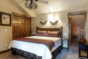 a bedroom with a large bed and a chandelier at 3 Bedroom In Lionshead Village At The Antlers in Vail