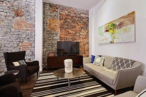 uma sala de estar com um sofá e uma televisão em GENERATIONS QUEBEC OLD CITY/ Parking/ Family em Quebeque