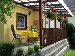 a patio with a yellow table and chairs on a house at Ferienwohnung Böhme in Marienberg