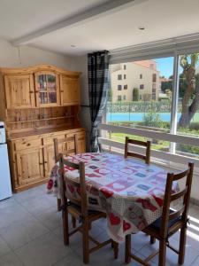 una cucina con tavolo, sedie e finestra di Appartement cosy à 500m de la mer a Plage dʼArgelès