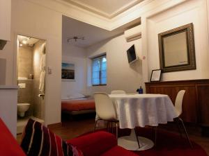 a room with a table and a bed and a bathroom at B&B "Clos Feuillat" in Lyon