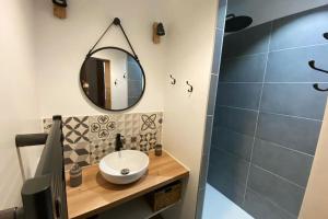 a bathroom with a sink and a mirror at L'Ilot du Perche: Appartement cosy avec jardin in Bellême