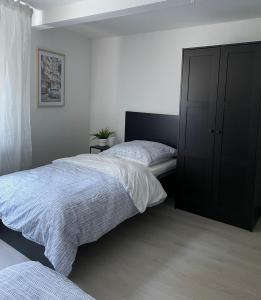 1 dormitorio con 2 camas y armario negro en - SANO Apartments - bei Uwe, en Hagen