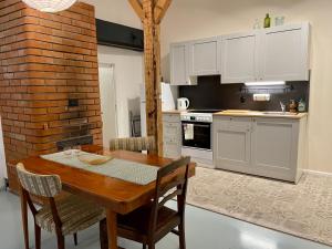 a kitchen with a wooden table and white cabinets at Spacious Apartment in Old Town in Viljandi
