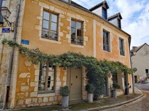 ein orangefarbenes Gebäude mit Pflanzen davor in der Unterkunft L'Ilot du Perche: Appartement cosy avec jardin in Bellême