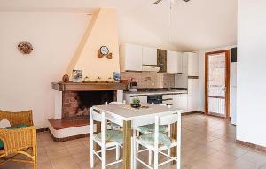 a kitchen with a table and a fireplace at Amazing Home In Torre Dei Corsari With Kitchen in Torre Dei Corsari