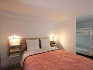 ein Schlafzimmer mit einem Bett mit zwei Leuchten in der Unterkunft Bel Appartement T2 Duplex en Hyper Centre, 3*, Parking, 4 Pers., Proche Thermes et Commerces - FR-1-608-233 in La Bourboule