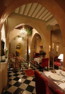 sala de estar con mesa y lámpara de araña en Riad Moullaoud, en Marrakech