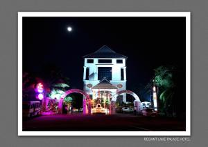 un edificio blanco con una torre iluminada por la noche en Regant Lake Palace Hotel, en Nīndakara