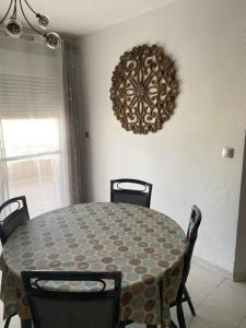 comedor con mesa, sillas y reloj en Apartamento Andalucía - vistas al mar, playa, puerto deportivo, garaje, en Garrucha