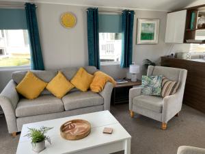 a living room with a couch and two chairs at 6 Berth Comfy Homely Caravan, Dog Friendly in Belton