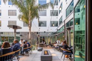 a patio with people sitting at tables in a building at Shashi Hotel Mountain View, an Urban Resort in Mountain View