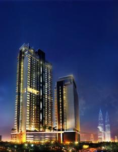 Sfera Residence Kuala Lumpur City Centre في كوالالمبور: مبنيان طويلان في مدينة في الليل