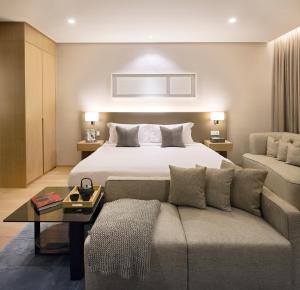 Sfera Residence Kuala Lumpur City Centre في كوالالمبور: غرفه فندقيه بسرير واريكه