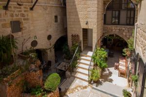ベツレヘムにあるBREAD HOUSEの階段と植物のある建物の屋内中庭