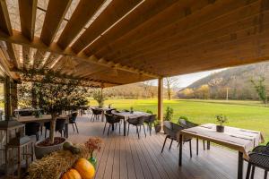 une terrasse en bois avec des tables et des chaises sur un champ dans l'établissement Old River Room, à Buzet