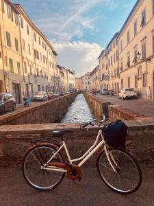 una bicicletta parcheggiata accanto a un canale con edifici di BnB Villa Melany vicino Centro a Lucca