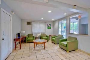 a waiting room with green chairs and a table at Motel 6 Virginia Beach in Virginia Beach