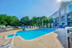 a swimming pool with chairs and a building at Motel 6 Virginia Beach in Virginia Beach