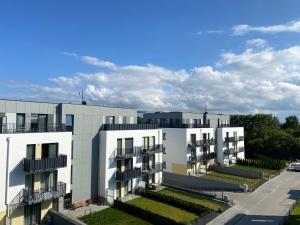 een appartementencomplex met twee witte gebouwen bij Apartamenty Poproszę Nad Morze in Jastrzębia Góra
