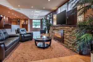 a living room with a couch and a fireplace at Best Western Plus, Bathurst Hotel & Suites in Bathurst