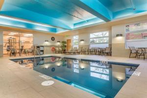 una piscina con soffitti e tavoli blu e sedie di Best Western Plus, Bathurst Hotel & Suites a Bathurst