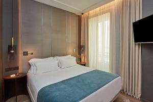 a hotel room with a large bed and a television at NH Collection Madrid Gran Vía in Madrid