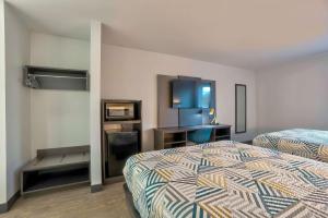 um quarto de hotel com duas camas e uma televisão de ecrã plano em Motel 6 Tulsa, Ok - Central em Tulsa