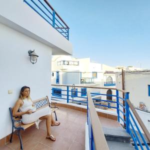 a woman sitting on a chair on a balcony at Cotillo Ocean in Cotillo