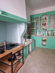 a kitchen with green cabinets and a table with pots and pans at St. António 49 in Faro