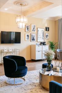 uma sala de estar com uma cadeira preta e uma mesa em Bogoria Residence - LoftAffair Collection em Cracóvia