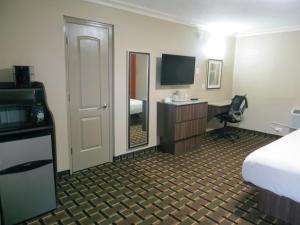 a hotel room with a bed and a desk at Budget Inn Lake Wales in Lake Wales