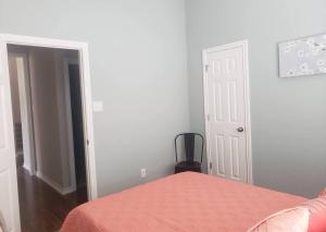 a bedroom with a bed with a orange bedspread and a mirror at Century Tree Lodge - Family & Football Friendly in College Station