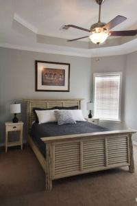 a bedroom with a large bed with a ceiling fan at Century Tree Lodge - Family & Football Friendly in College Station