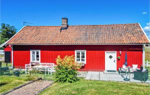 a red house with a red roof and white doors at Nice Home In sa With Kitchen in Åsa