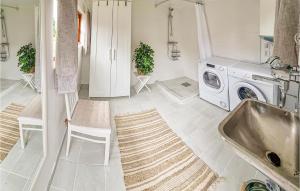 a bathroom with a washing machine and a sink at Nice Home In sa With Kitchen in Åsa