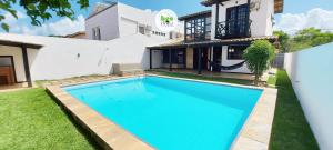 a swimming pool in front of a house at COSTE0101 - Casa com piscina em Stella Maris in Salvador