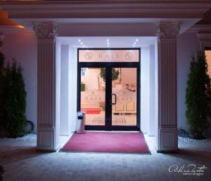 a front door of a store with a red rug at Hotel Rais in Târgu Jiu